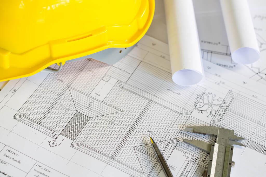Desenho técnico de planta arquitetônica com capacete de segurança e ferramentas de medição.